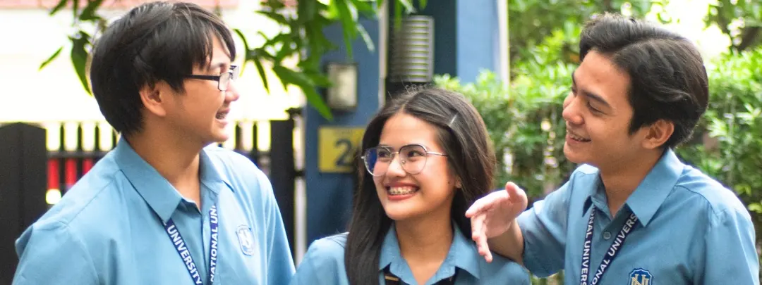 Three NU students talking outside a campus building